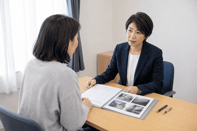 近所の嫌がらせの証拠を相談担当者に見せる女性