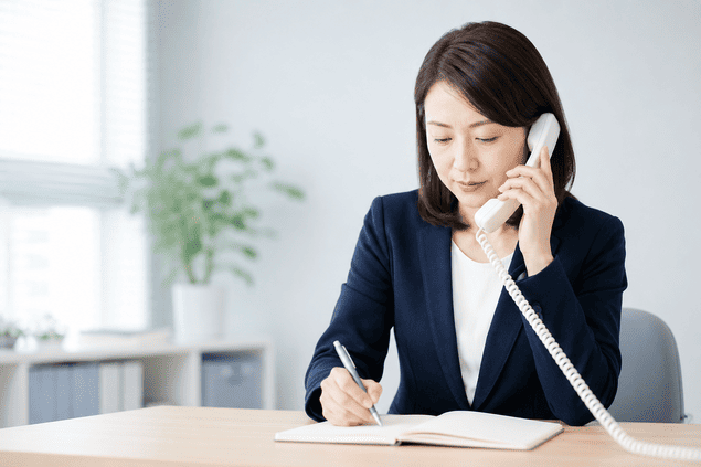 マッチングアプリで貸したお金の相手と連絡が取れず悩む相談者の電話を受ける女性相談員