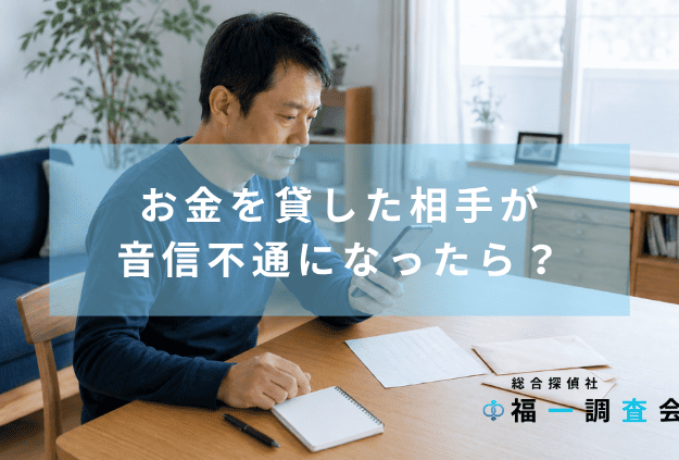 お金を貸した相手と連絡が取れず、封筒や旧住所の情報を前にスマートフォンを確認する男性