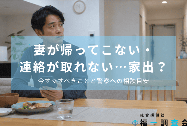 妻が帰ってこず、スマートフォンを手に玄関を気にする夫