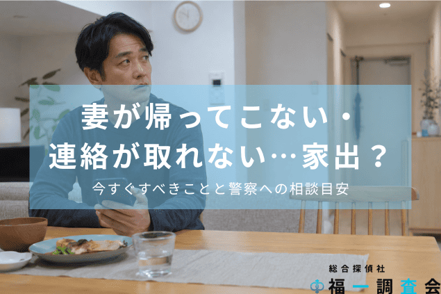 妻が帰ってこず、スマートフォンを手に玄関を気にする夫